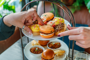 hands grabbing food from english afternoon tea set